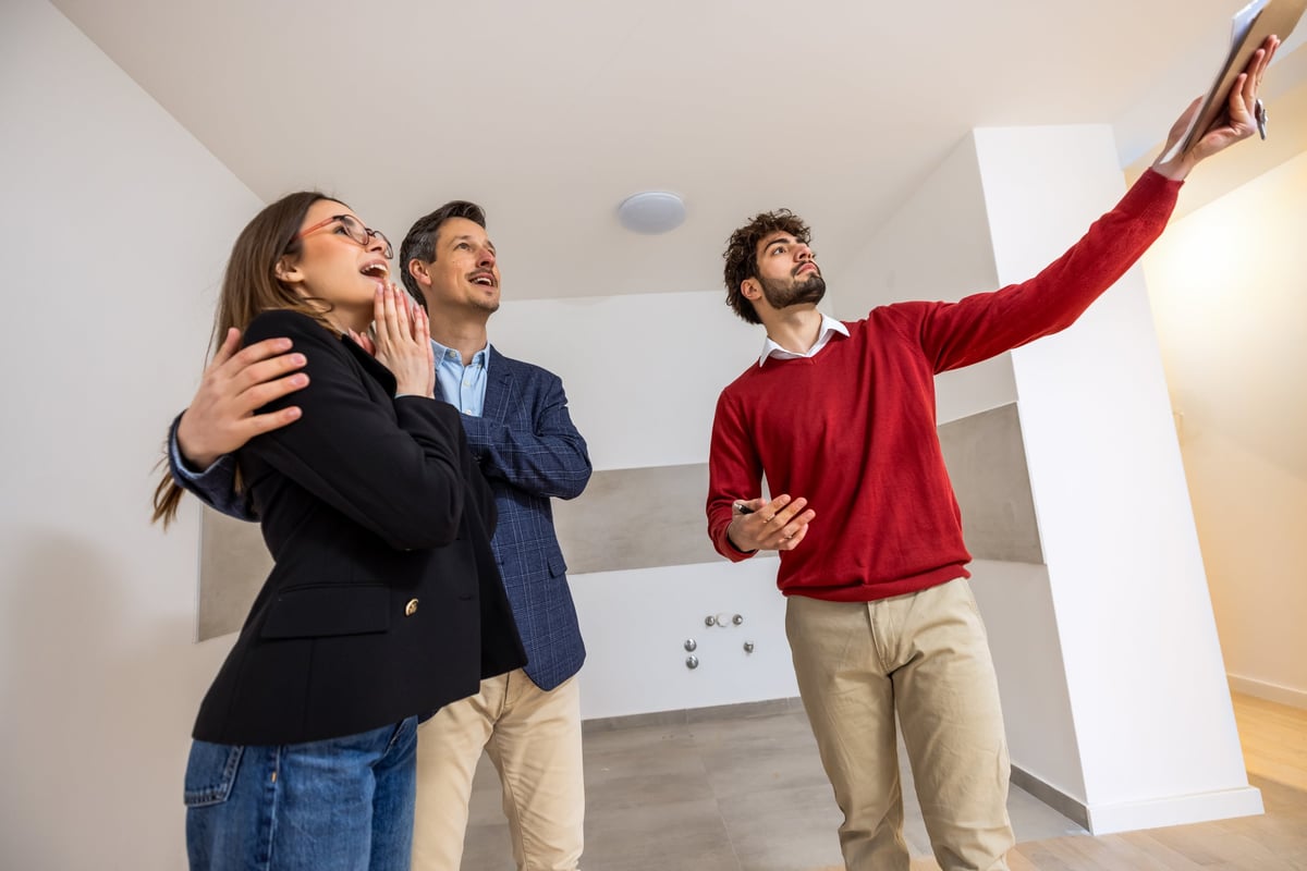 A joyful man and woman reacting with surprise and happiness during a property viewing